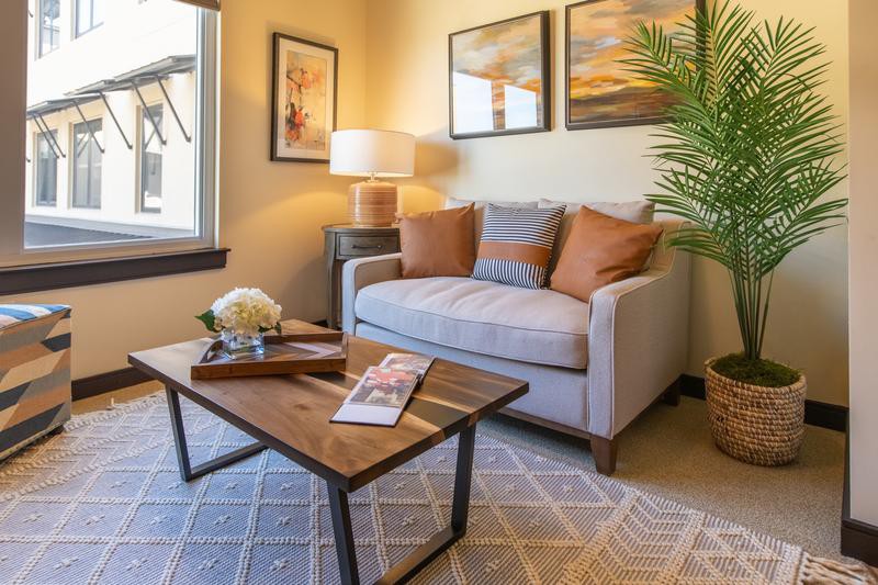 Cozy living room with a modern sofa, wooden coffee table, and soft lighting.