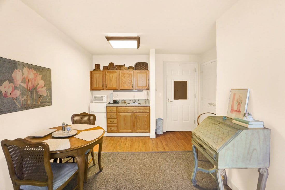 A cozy kitchen and dining area with wooden cabinets and a small dining table.