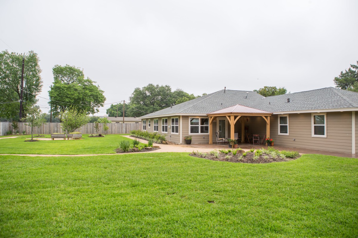 A suburban house with a spacious backyard and well-maintained lawn.