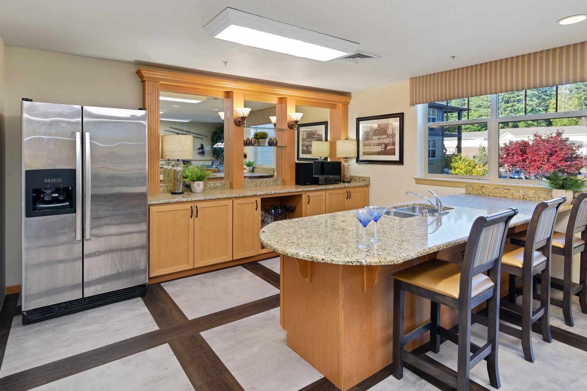 A modern kitchen with wooden cabinets and a granite countertop dining area.