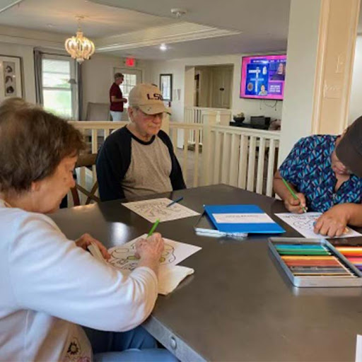 A group of people engaged in a drawing activity at a table indoors.