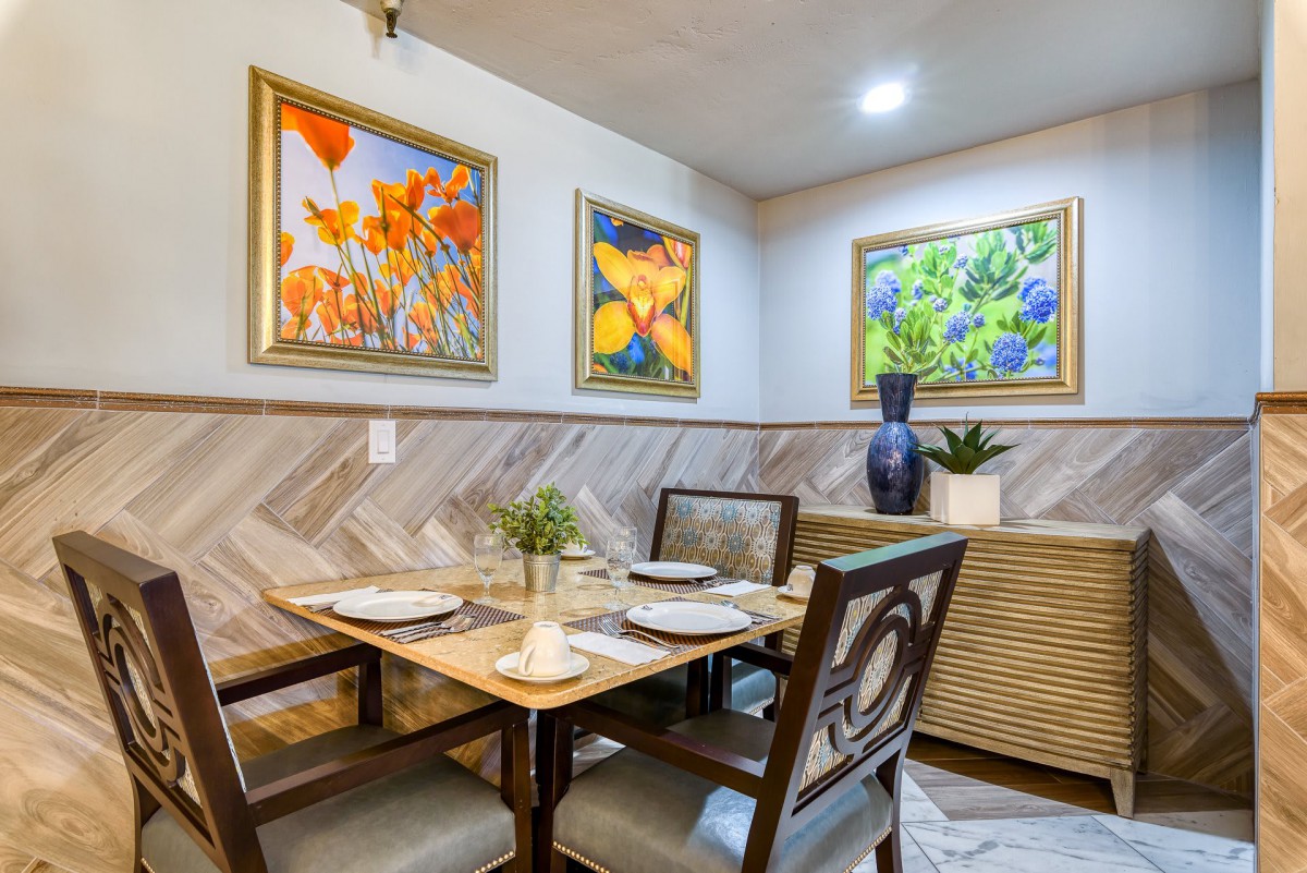A cozy dining room featuring colorful artwork and a neatly set table.