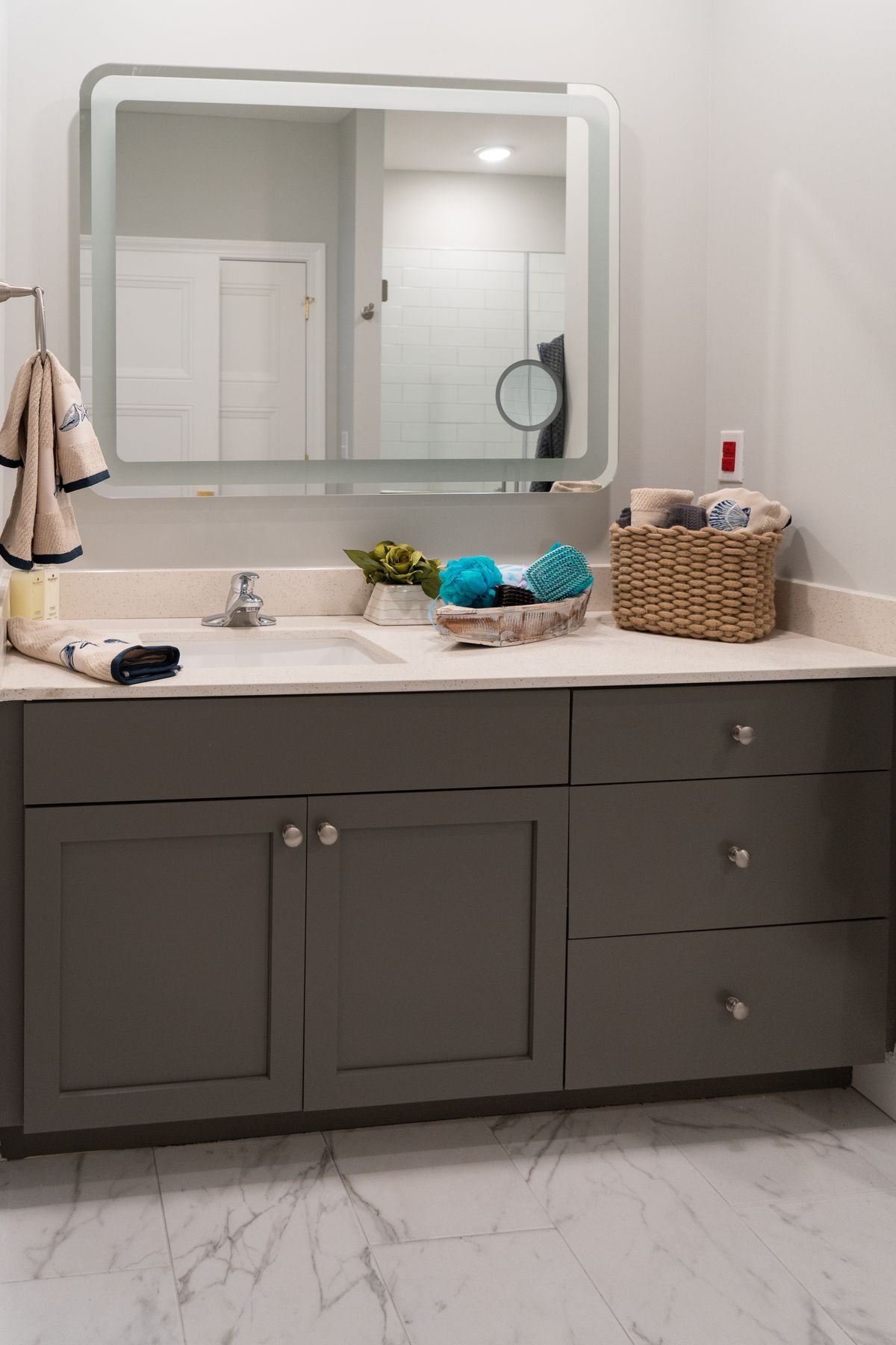 A modern bathroom vanity with a mirror, sink, and assorted toiletries.