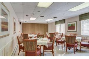 An empty dining room with neatly arranged tables and chairs, set up for service.