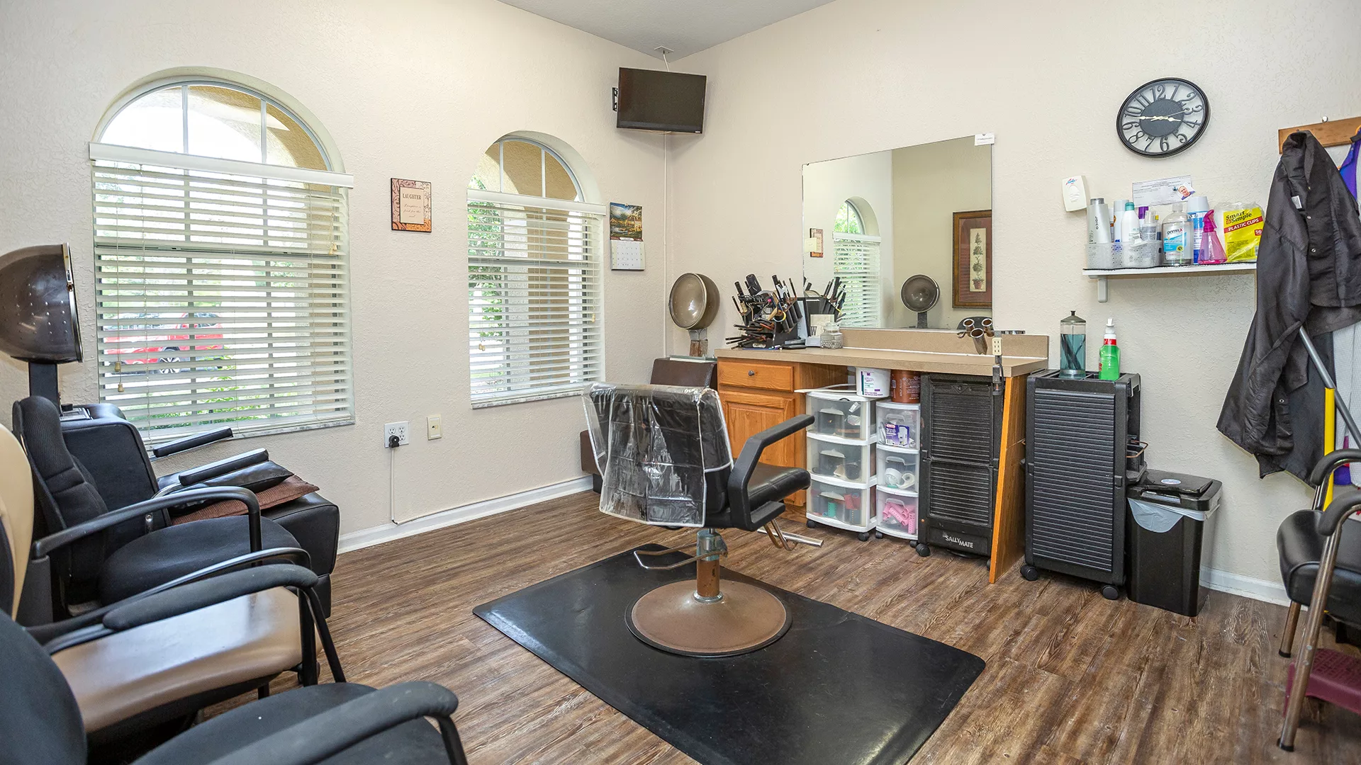 A clean and organized hair salon interior with a styling station and chair.