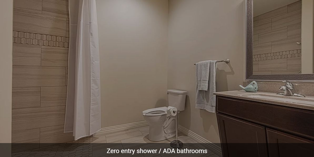 An ADA-compliant bathroom featuring a zero-entry shower and accessibility features.