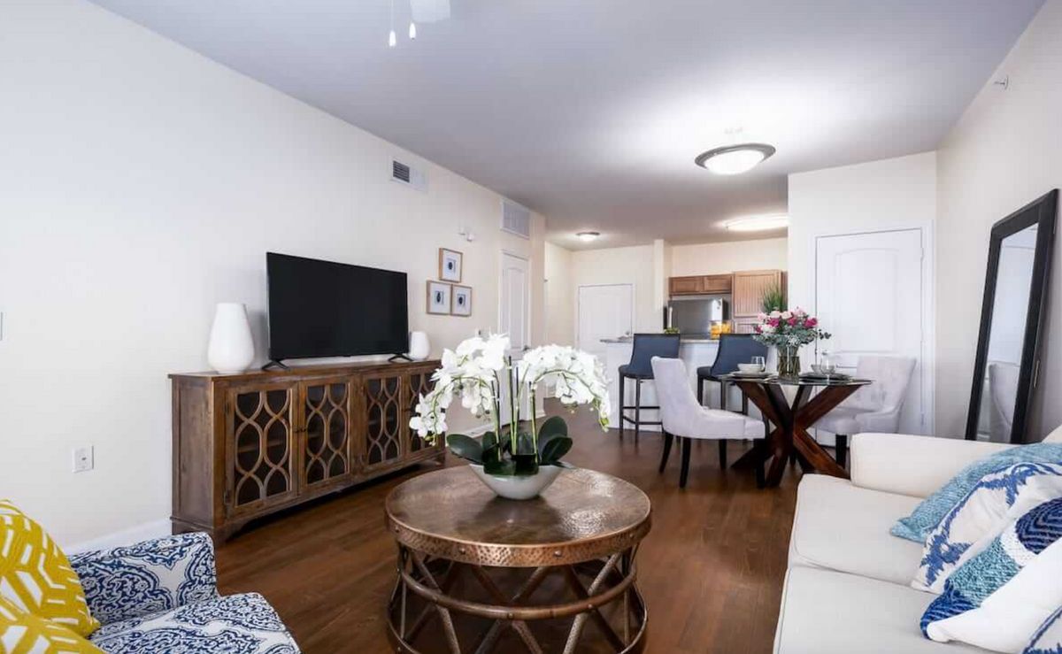 A modern living room with elegant decor and an open view into the kitchen.