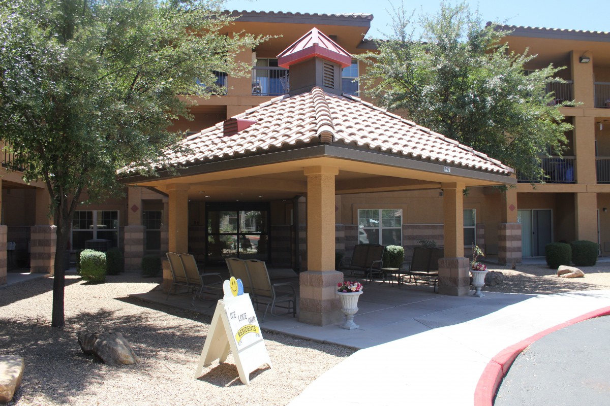 An outdoor view of a building entrance with a covered porch and tiled roof.
