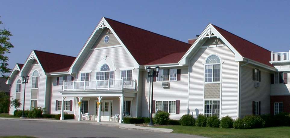 A two-story house with a red roof and white siding.