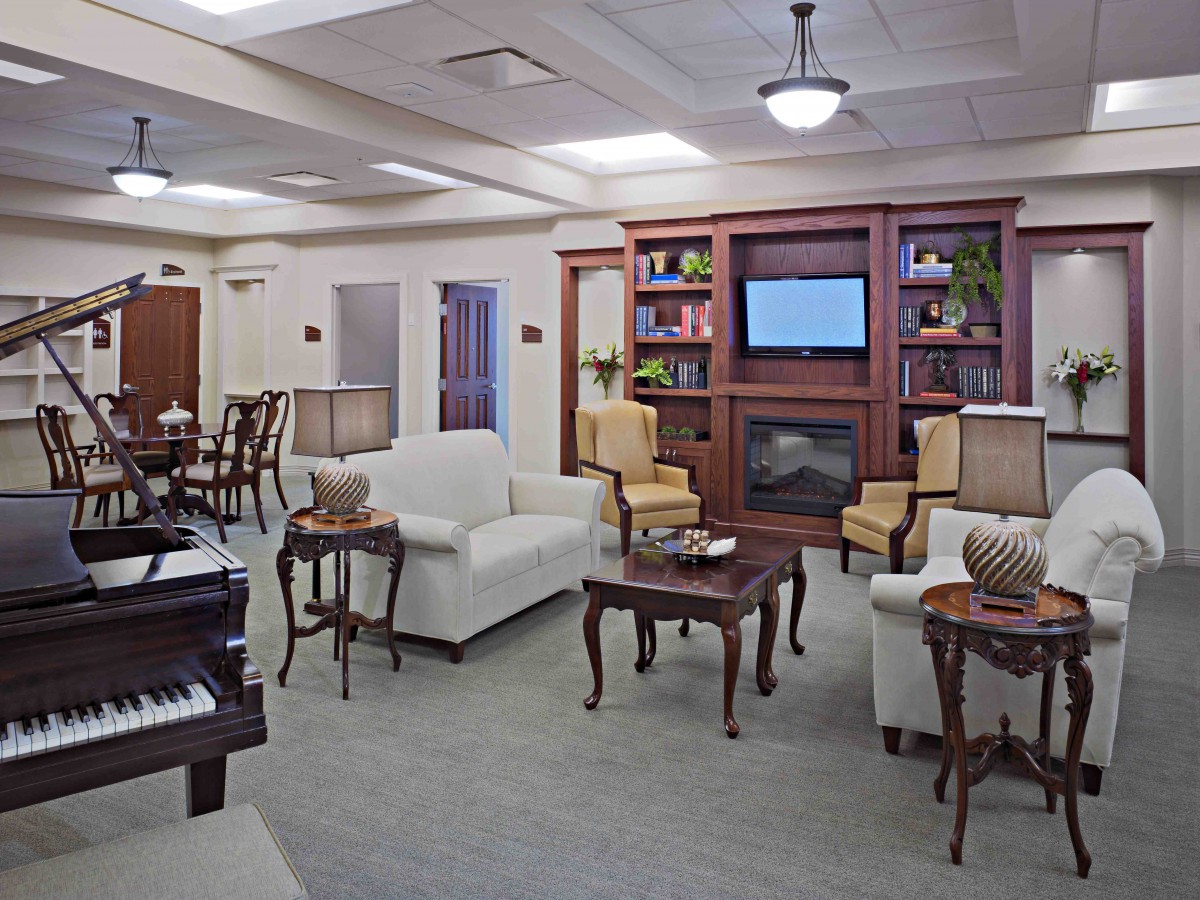 A cozy living room with comfortable seating, a bookshelf, and a television.