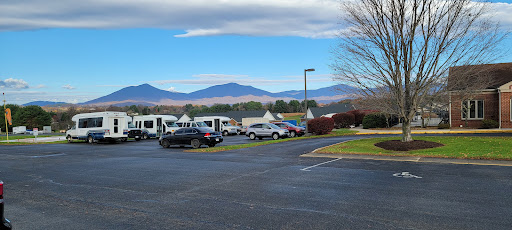 A scenic view featuring a parking lot surrounded by mountains and clear blue skies.