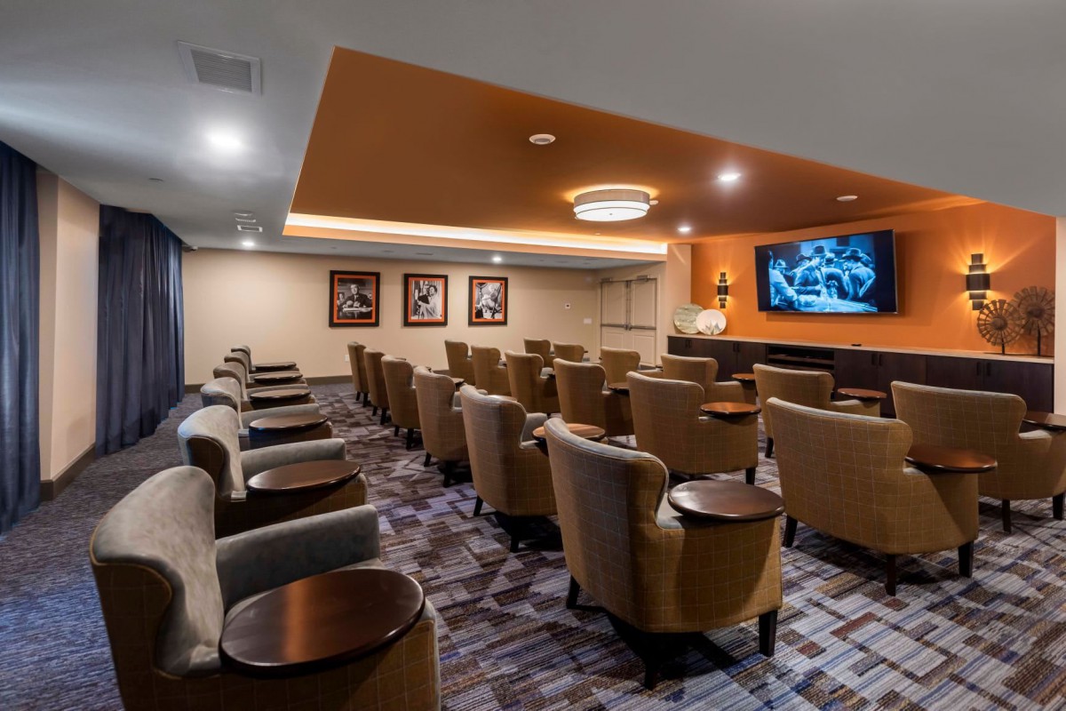A well-equipped theater room featuring rows of comfortable seating and a large projector screen.