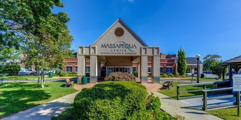 A well-maintained building entrance with visible signage and surrounding greenery.