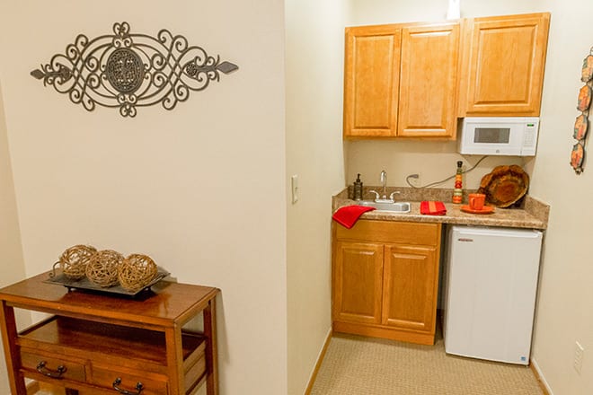 A compact kitchen with wooden cabinets and appliances.