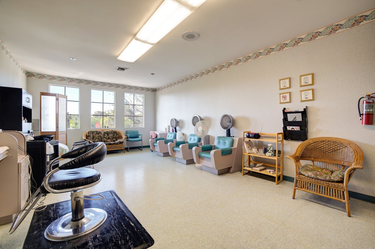 A well-lit salon with hair dryers and a comfortable waiting area.