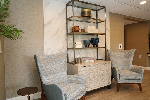 A modern interior setup featuring stylish chairs and an open shelving unit adorned with decorative items.