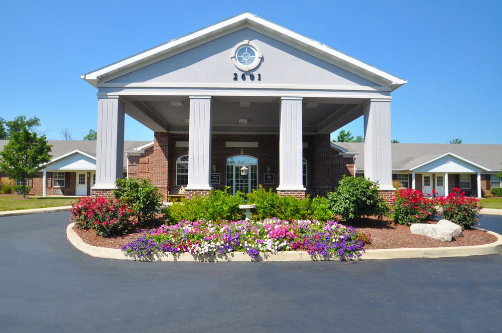 A well-maintained building entrance adorned with colorful flowerbeds.