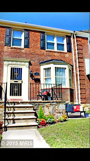 A charming brick house with a welcoming front porch and colorful flowers.