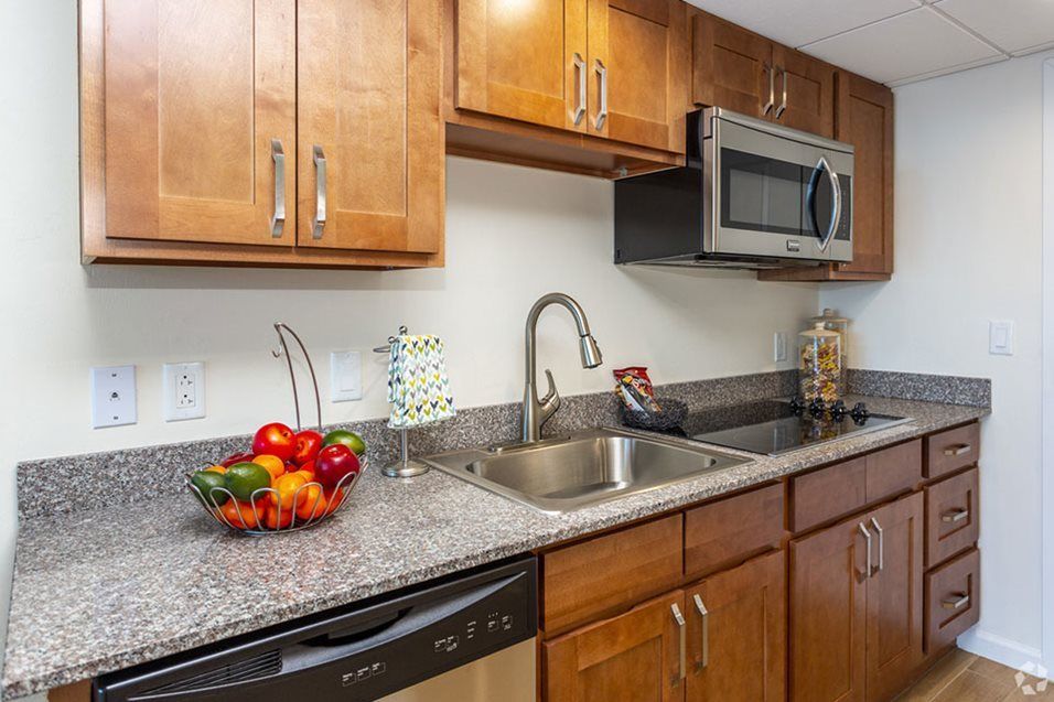 A modern kitchen with wooden cabinets, a stainless steel sink, and appliances.