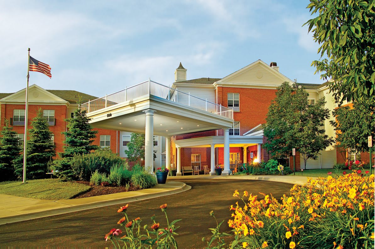 A modern building with a landscaped entrance and vibrant flowers.