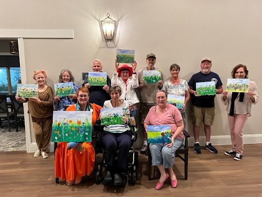 Participants proudly display their artwork during a fun and creative community art class.