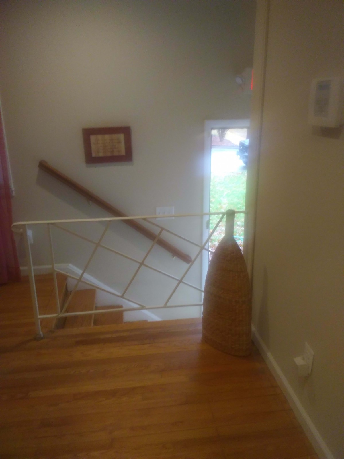 Indoor staircase leading to an open doorway with natural light.