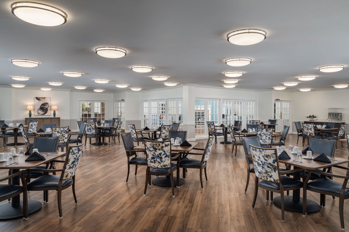 A spacious and modern dining room with neatly arranged tables and chairs.