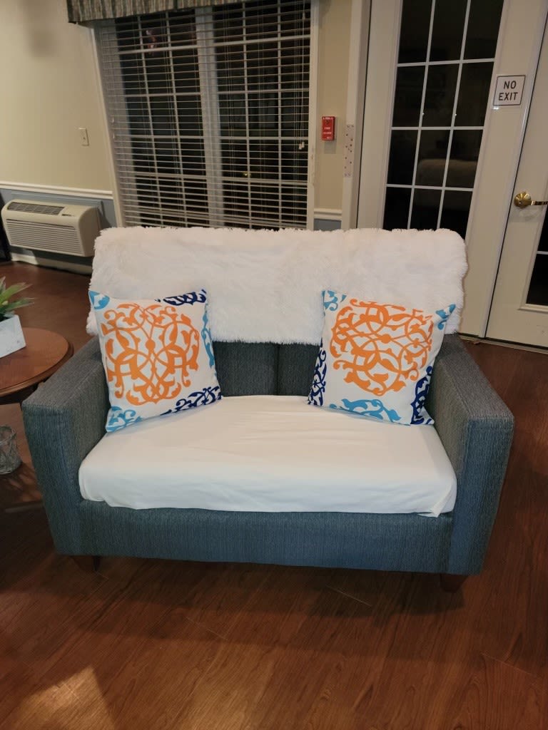 A cozy loveseat adorned with colorful pillows and a soft throw in a stylish living room.