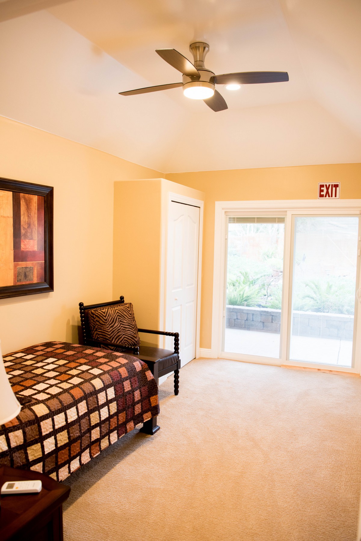 A cozy bedroom with a single bed, chair, and large window providing ample natural light.
