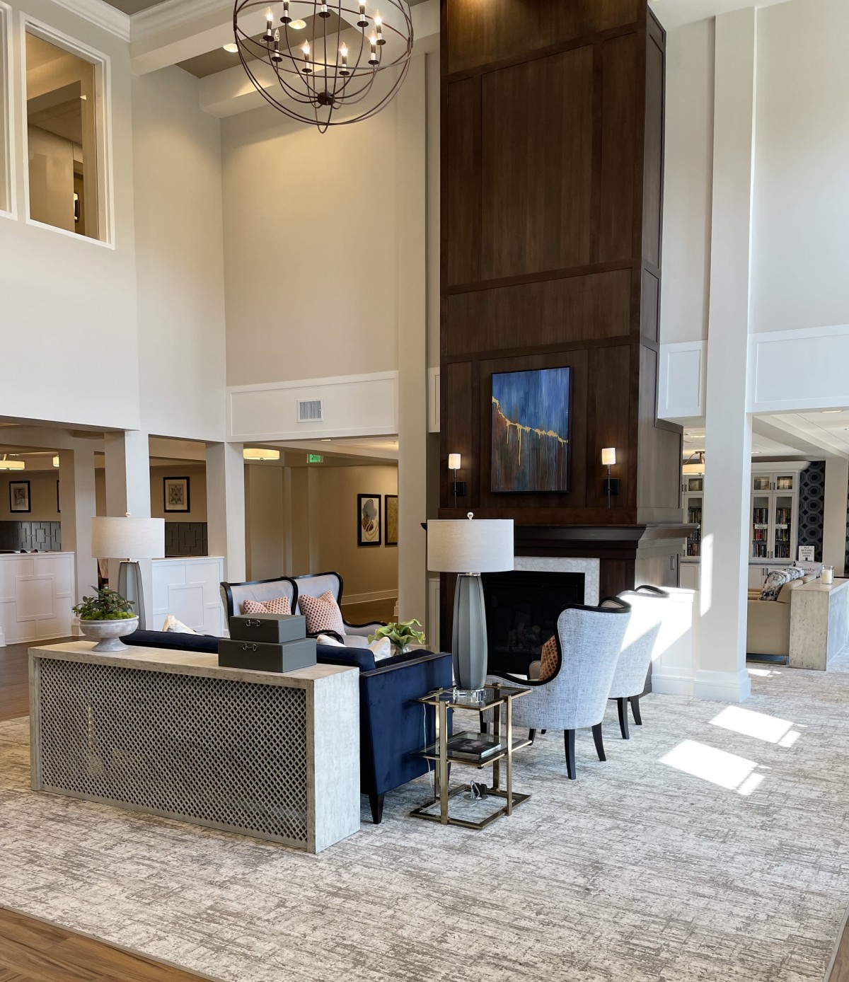 A spacious and elegantly designed lobby featuring modern furniture and a high ceiling.