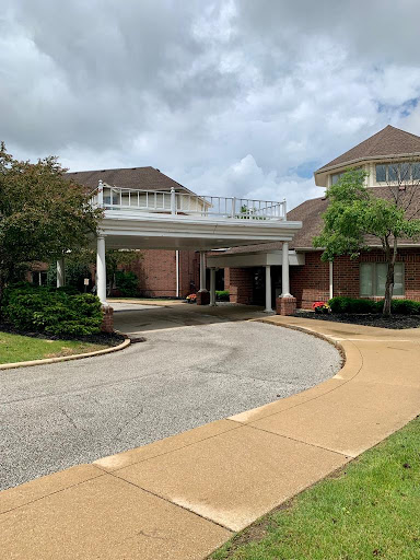 A welcoming entrance to a well-designed building, surrounded by neatly landscaped greenery.