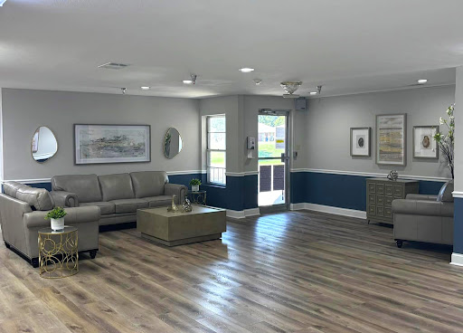 A bright and spacious living room featuring modern furniture and a stylish blue accent wall.