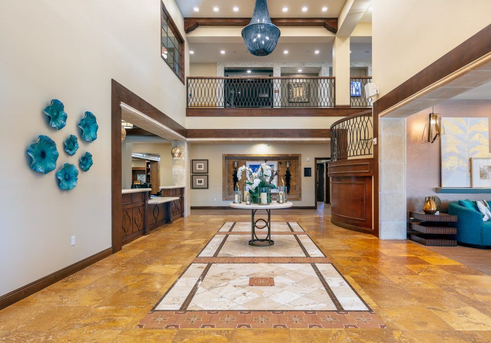 A spacious and modern lobby with elegant architectural details and a large chandelier.