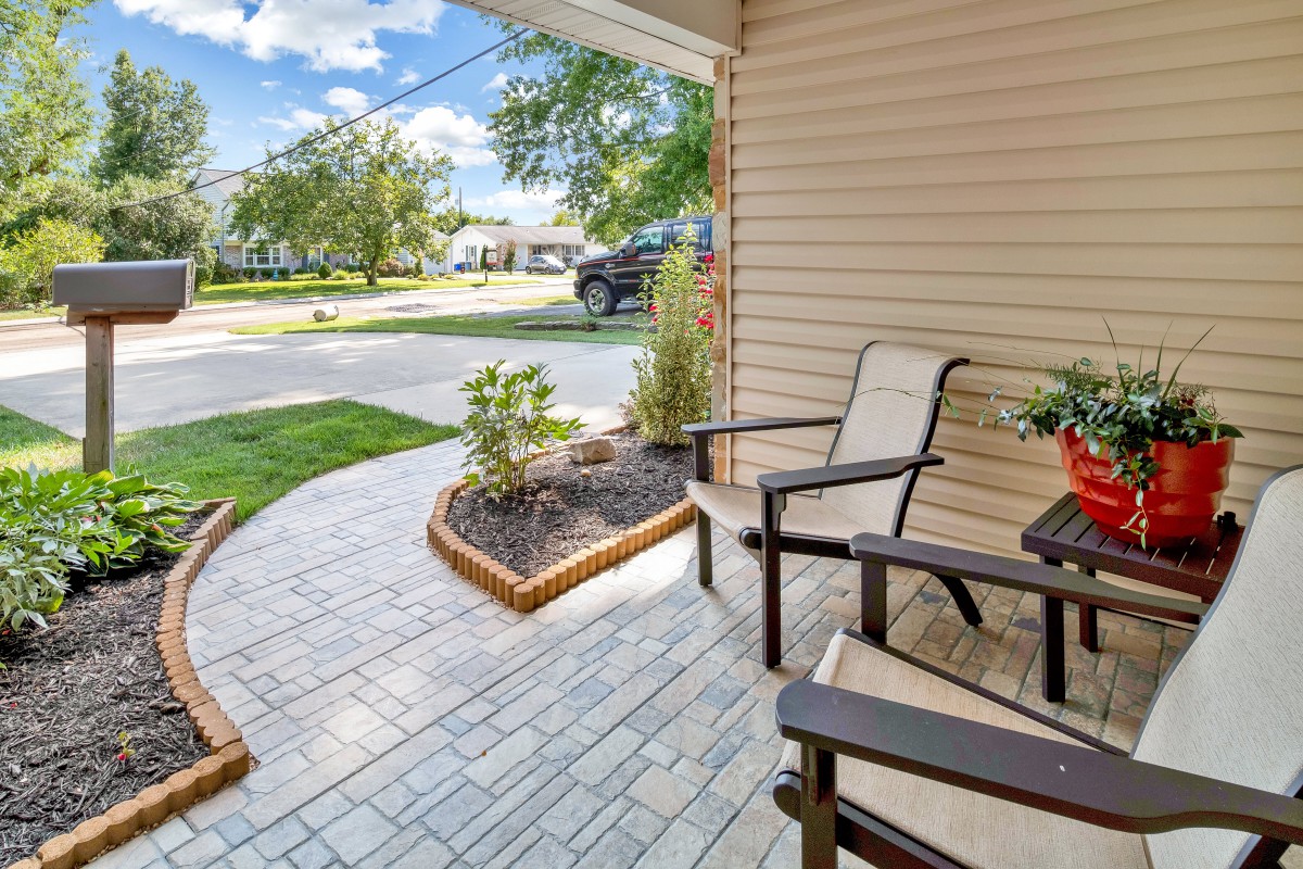 A cozy porch with chairs and a small garden area, perfect for relaxing.