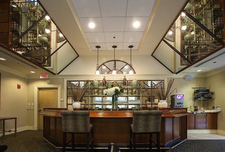 A modern hotel lobby with a reception desk, elegant lighting, and decorative mirrors.