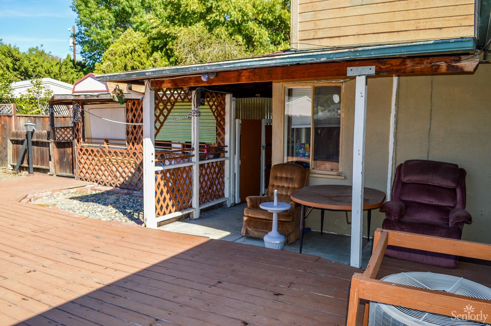 A sunny outdoor patio with wooden decking and comfortable seating.