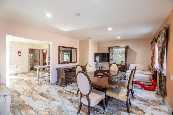 A well-furnished dining room with a wooden table, upholstered chairs, and elegant decor.