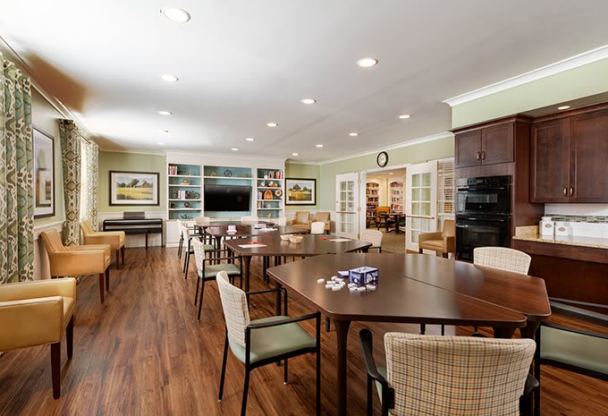 A modern meeting room with a large conference table, chairs, and bright lighting.