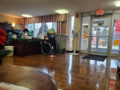 A cozy lobby with a reception desk and a wheelchair, designed for accessibility.