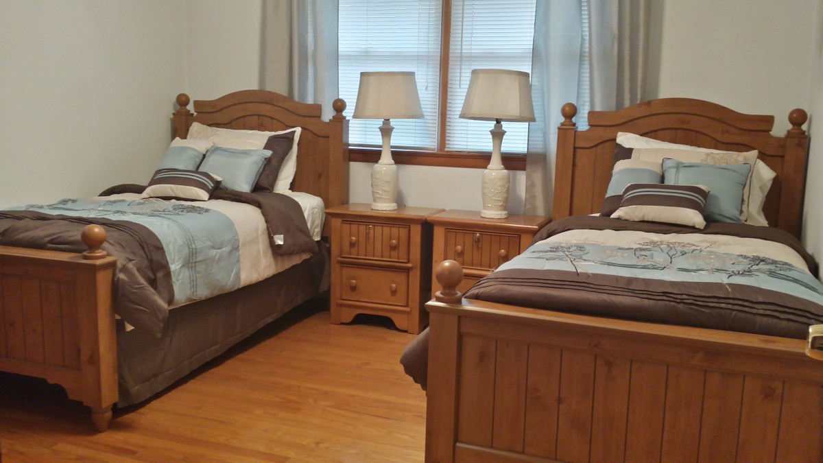A cozy bedroom with twin wooden beds and matching bedside lamps.
