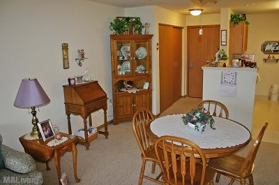A cozy dining area with a wooden table, chairs, and a china cabinet.