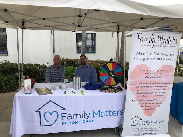 An information booth for Family Matters In-Home Care with promotional materials and a spin wheel.