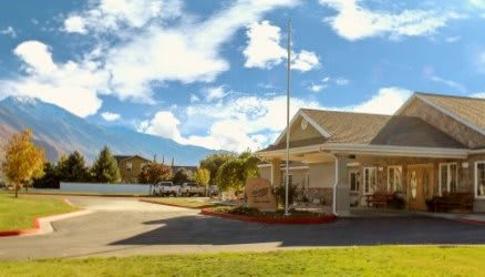 A suburban building with a driveway under a partly cloudy sky.