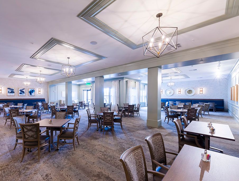 Spacious restaurant dining area with modern lighting and neatly arranged tables.