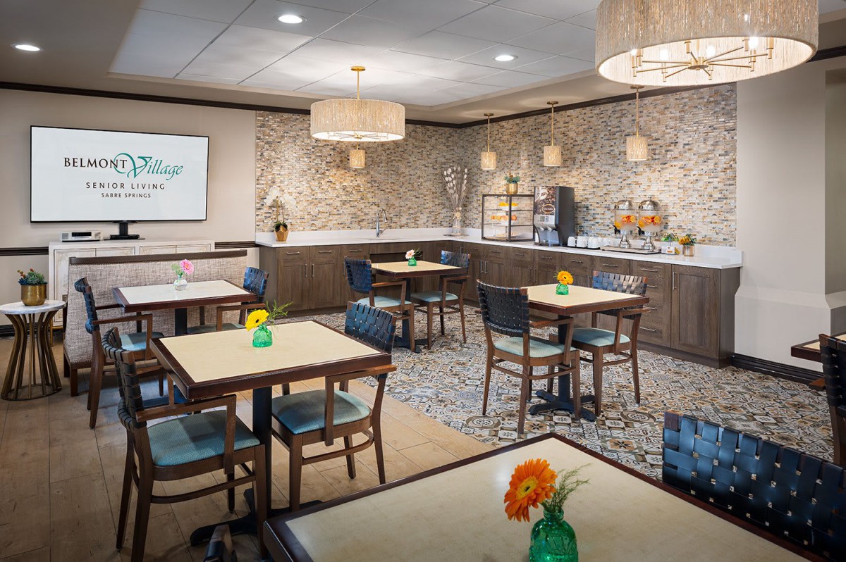 A cozy dining area with modern decor and floral arrangements on the tables.