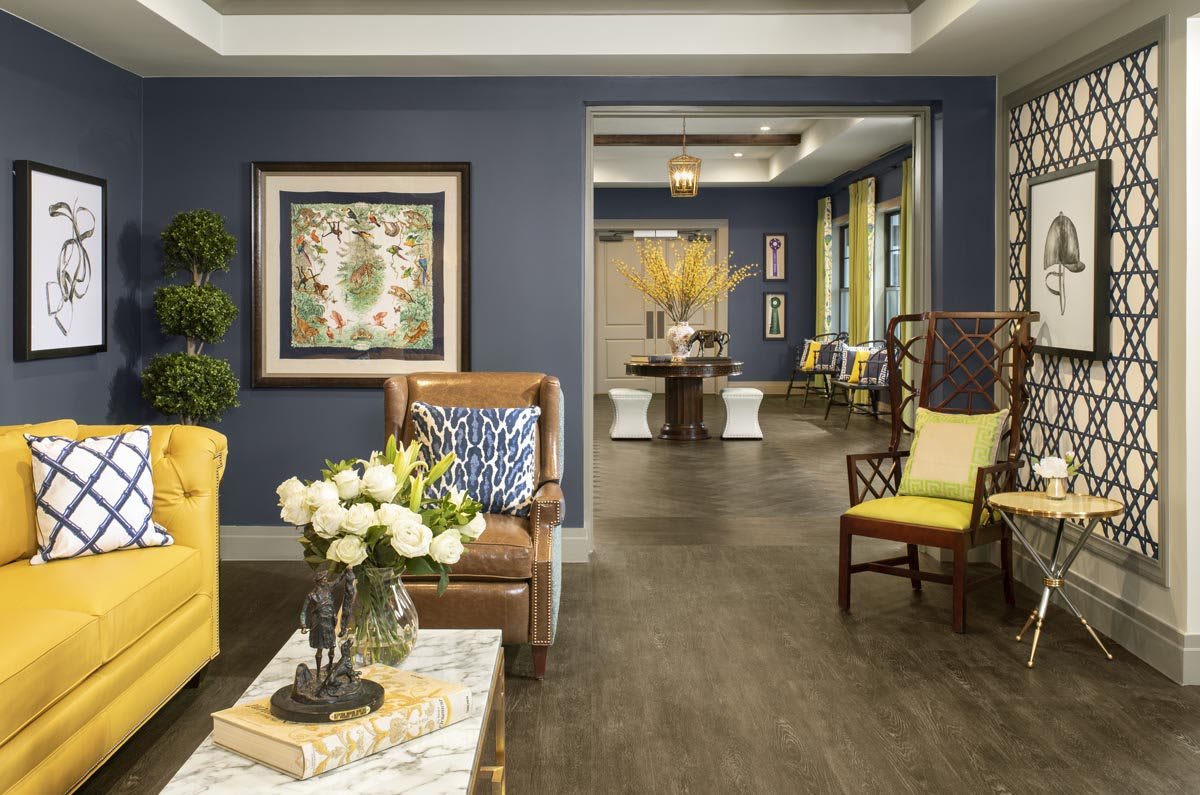 A cozy living room with blue walls, decorated with elegant furniture and floral accents.