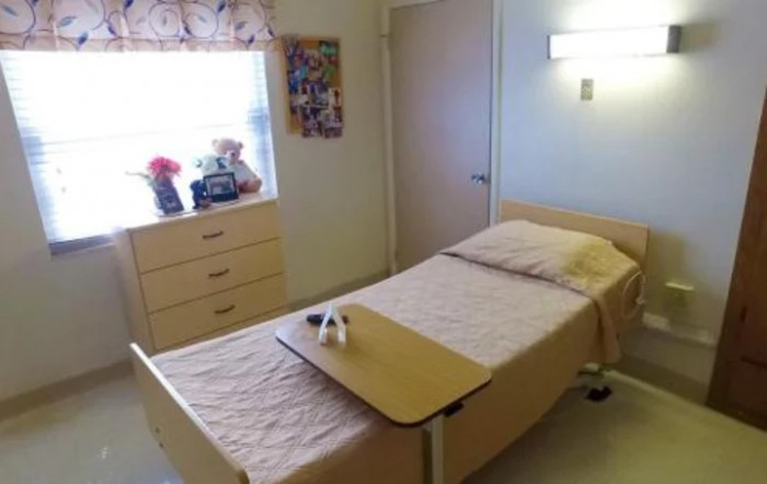 A hospital room with a single bed and medical equipment.