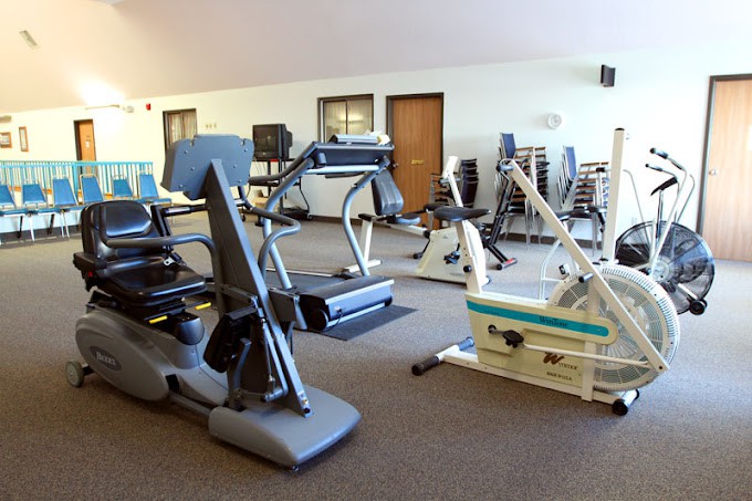 A fitness center with various exercise equipment including cardio machines and strength training gear.