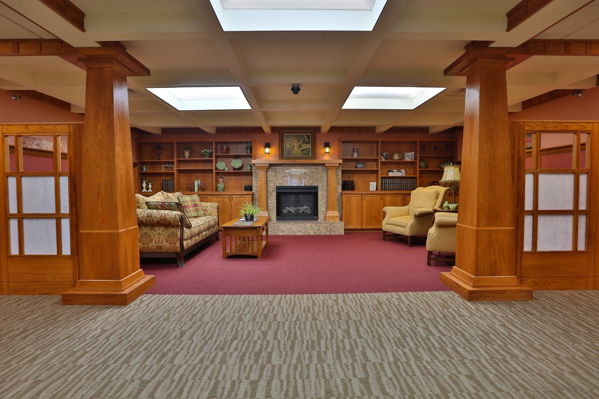 Cozy library interior with a fireplace and comfortable seating.