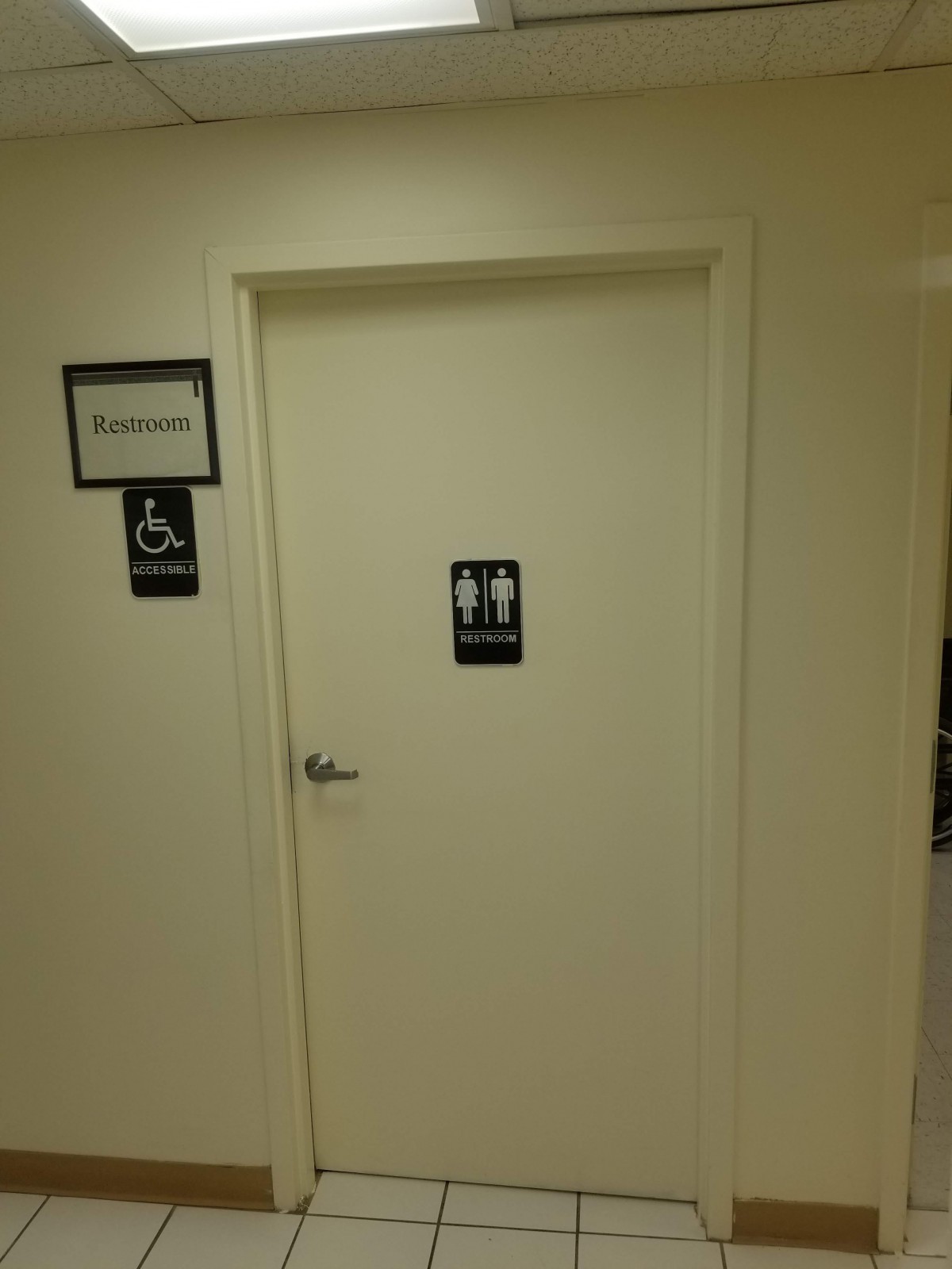 A restroom door with accessibility signage.